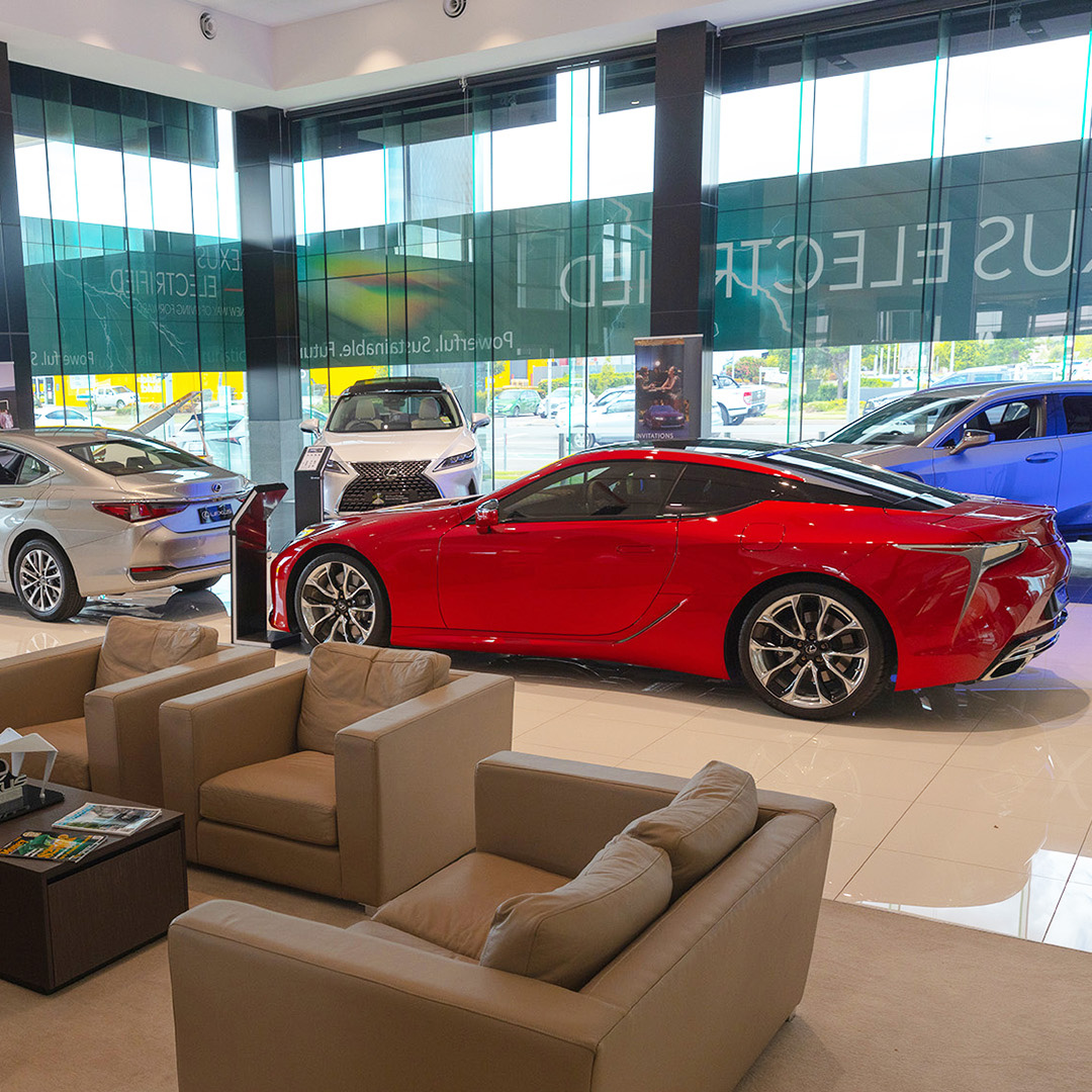 The showroom of Lexus of Townsville. A red LC 500 can be seen in front of a beige sitting area.