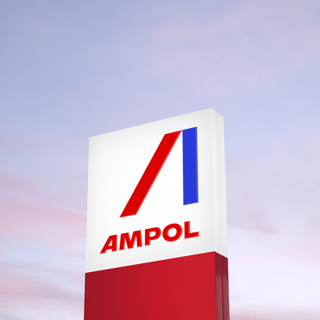 An Ampol sign stands in front of a pink purple sky.